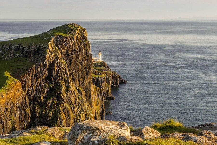 Bílý maják Neist Point na konci skalnatého útesu při roadtripu po Isle of Skye