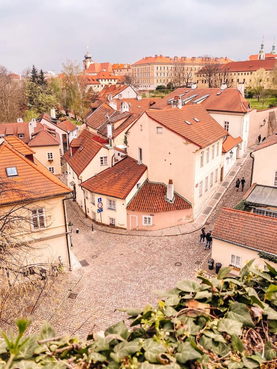 Pohled na malebnou a klidnou uličku Nový svět v Praze. Fotka zachycuje dlažbu, historické domky s barevnými fasádami a klidnou atmosféru skrytého koutu Hradčan.