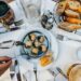 Typická francouzská jídla - gratinovaní šneci na stole ke sdílení s přáteli