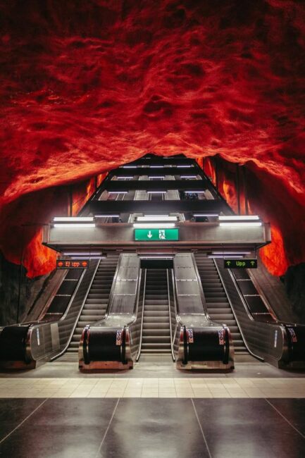 Dramatický červený strop stanice metra Solna centrum ve Stockholmu znázorňující západ slunce nad lesem, nejdelší umělecká galerie světa. Součást itineráře Stockholm na 3 dny.