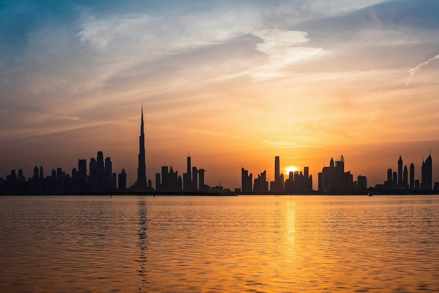 Panorama Dubaje při západu slunce s Burj Khalifa v pozadí. Pohled přes vodu, který musíte vidět v Dubai Creek Harbour. Tip na to, co vidět v Dubaji zdarma.