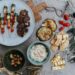 typická řecká jídla - olivy, souvlaki, hummus, rajčata a další zelenina na prostřeném stole