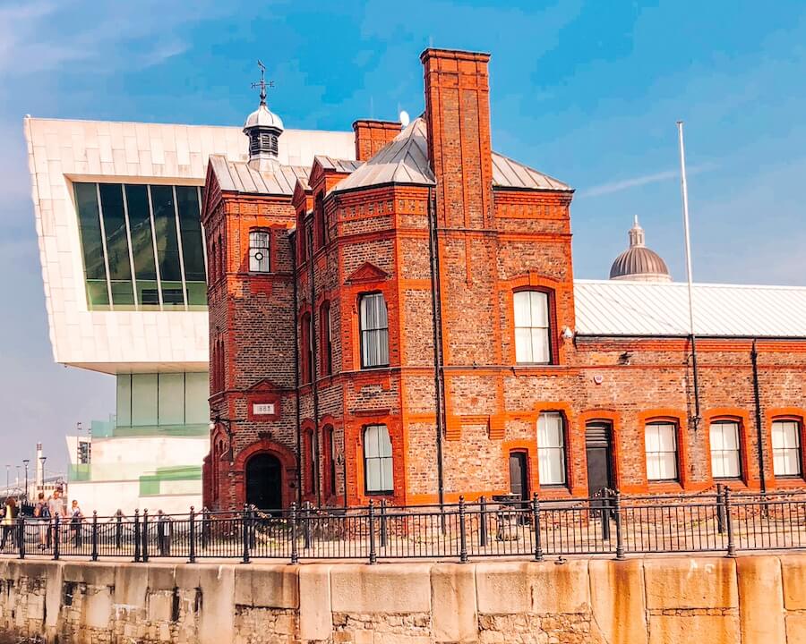 Co vidět v Liverpoolu? Navštivte třeba Museum of Liverpool - je zdarma. Na fotografii v pozadí, v popředí červená cihlová budova.