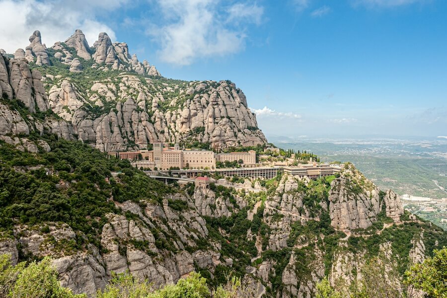 Panorama kláštera Montserrat vytesaného do skal. Ideální cíl pro celodenní výlet z Barcelony v rámci Barcelona itineráře od Blond on the Road..