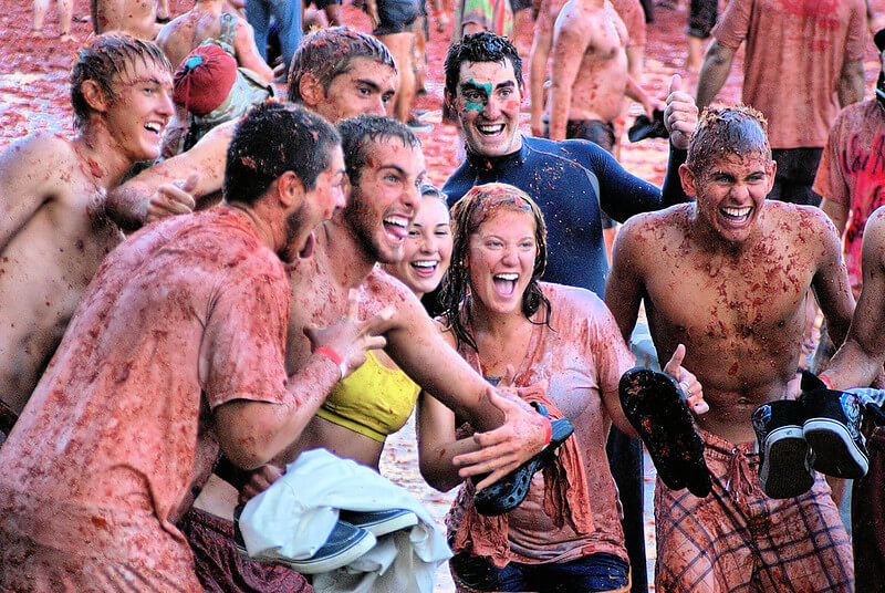 Skupina lidí pokrytá rajčatovým pyré během La Tomatina, tradice ve Španělsku a festival ve Valencii.