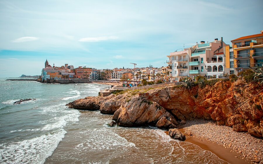 Pobřežní promenáda v Sitges s výhledem na kostel, oblíbený cíl pro krátké výlety z Barcelony.