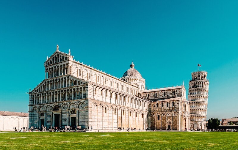 Panoramatický pohled na mramorovou katedrálu a Šikmou věž na zeleném trávníku, jednodenní Pisa itinerář.