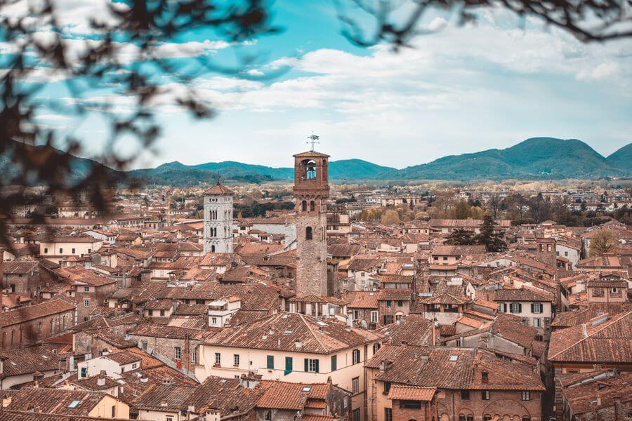 Panoramatický pohled na historické střechy a věže městečka Lucca v Toskánsku, ideální cíl pro nejpohodovější výlety z Pisy.
