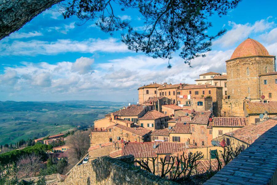 Kamenné středověké uličky a budovy historického města Volterra na kopci, které nabízí nejlepší výlety z Pisy za historií a atmosférou.