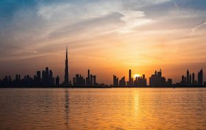 Panorama Dubaje při západu slunce s Burj Khalifa v pozadí. Pohled přes vodu, který musíte vidět v Dubai Creek Harbour. Tip na to, co vidět v Dubaji zdarma.