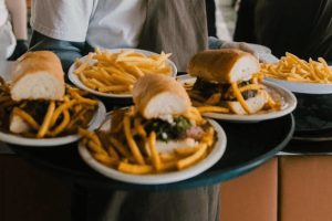 Nejlepší sendviče v Praze: Detail na rozříznutý bohatě plněný sendvič s masem, sýrem a nakládanou okurkou z podniku Sandwich Rodeo. Tip na rychlý oběd v Praze.