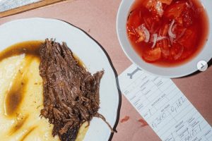 Moderní česká kuchyně v restauraci Kantýna v Praze: Detailní záběr na trhané hovězí maso s kaší a přiloženou účtenkou. Skvělý tip, kam na oběd v Praze pro milovníky masa.