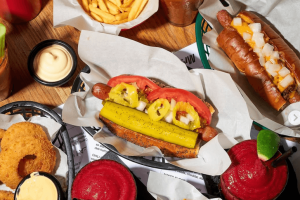 Kam na jídlo v Praze na street food: Detailní záběr na legendární hotdog s vídeňskou cibulkou, hranolky a domácí limonádu v podniku Mr. HotDog na Letné.