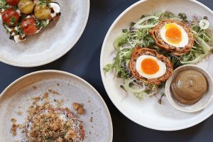 Moderní gastronomie v Praze: Minimalistické talíře s kreativně připraveným tatarákem a vejcem obaleným v mase. Gastro zážitek v článku kam na jídlo v Praze - restaurace Spojka Karlín.